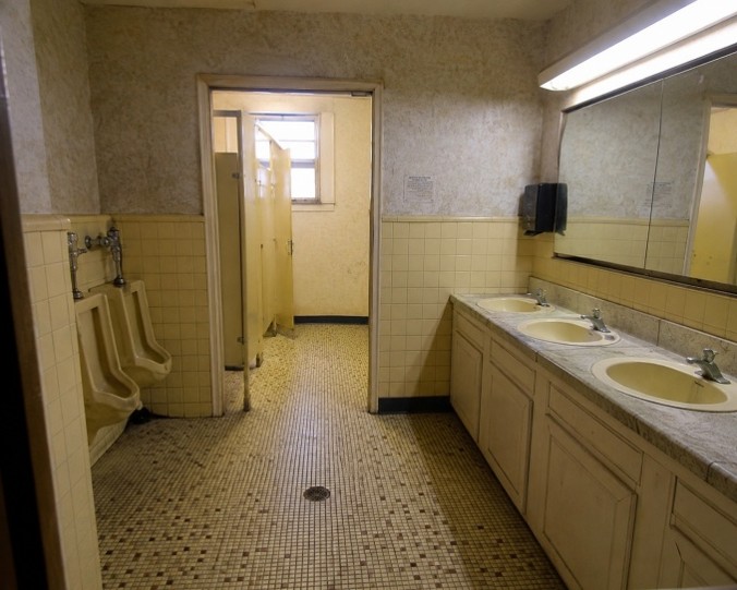 Before photo of an older commercial restroom before modernization upgrades